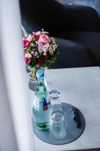a bottle of water and two glasses on a table at Hotel des Nordens Flensburg Wellness & Spa in Flensburg