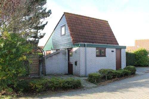 une petite maison blanche avec un toit marron dans l'établissement Het Coraaltje, à Julianadorp