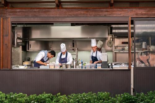 a group of chefs preparing food in a kitchen at Le Calette Bay in Cefalù