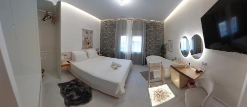 a white bedroom with a bed and a television at My Hersonissos Home Brand New Luxury apt in Limín Khersonísou