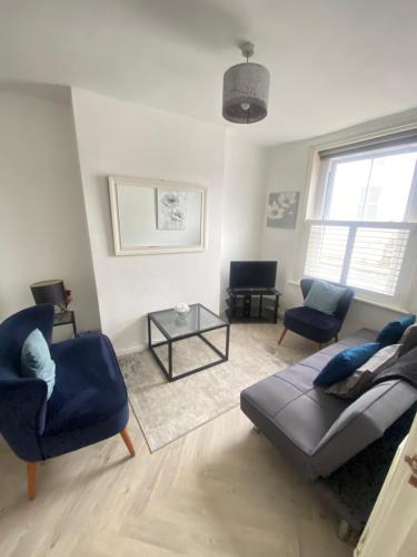 a living room with a couch and chairs and a table at City Centre 4 Bedroom House in Winchester