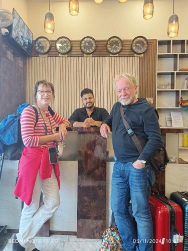 a man and a woman standing at a counter with luggage at Hotel Imperial inn in Mumbai