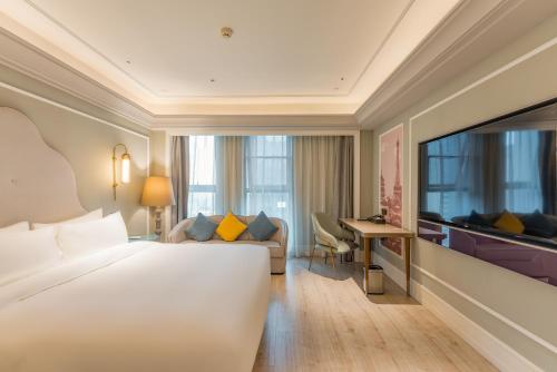 una habitación de hotel con una cama y un sofá en Mercure Hotel Hangzhou East Railway Station, en Hangzhou