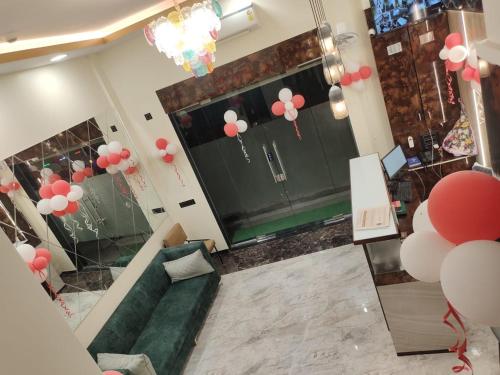 a living room with a green couch and pink balloons at Hotel Imperial inn in Mumbai
