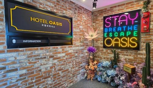 a sign on a brick wall with a tv on it at Sokcho hotel Oasis in Sokcho