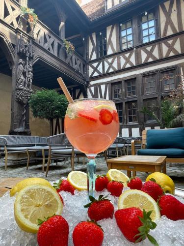 a drink sitting on a table with strawberries and lemons at Maison Philippe Le Bon Hôtel, Restaurant & Bar le 19 in Dijon