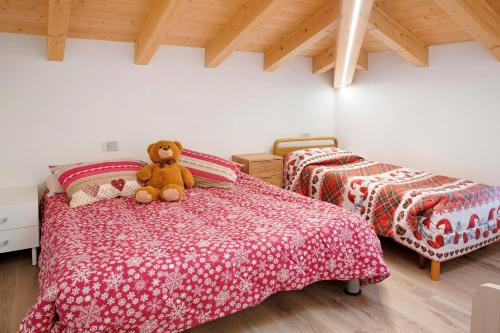 a teddy bear sitting on a bed in a bedroom at Sam Fiamet in Grosio