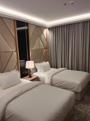 a hotel room with two beds and a window at فندق رافيليا Rafellia Hotel in Ahad Rafidah