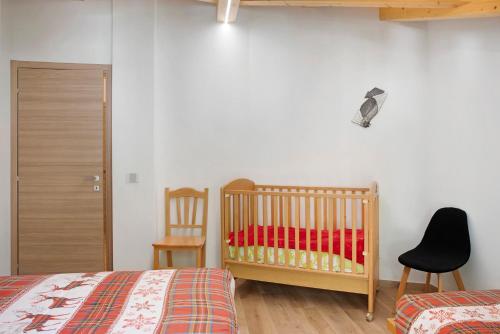 a bedroom with a crib and a chair at Sam Fiamet in Grosio