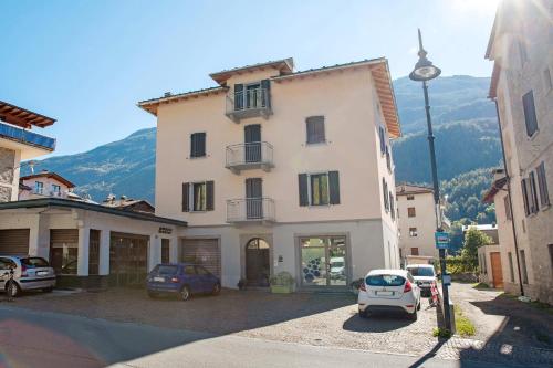 a large white building with cars parked in a parking lot at Sam Fiamet in Grosio