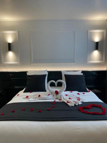 a bed with two white swans and hearts on it at Maison Philippe Le Bon Hôtel, Restaurant & Bar le 19 in Dijon