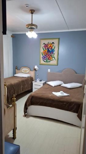 a bedroom with two beds and a blue wall at Nova Vicenza Hotel in Farroupilha
