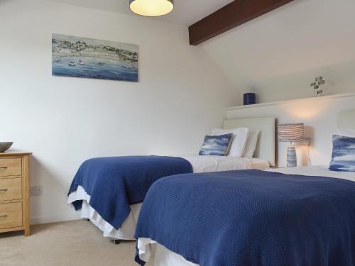 two beds in a bedroom with blue and white at Brameley in Cheriton Bishop