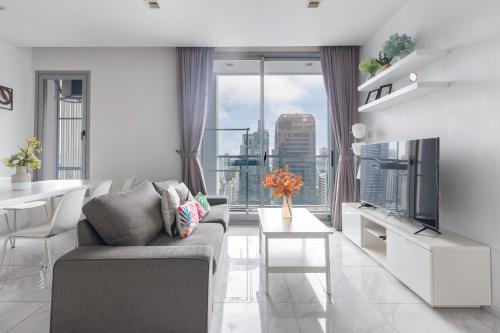 a living room with a couch and a large window at The Echelon Sukhumvit 11 by LeFoyer in Bangkok