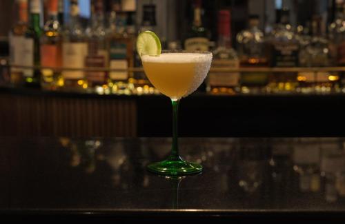 a martini glass with a lime on a bar at The Posthouse Berlin Potsdamer Platz- Leonardo Limited Edition in Berlin