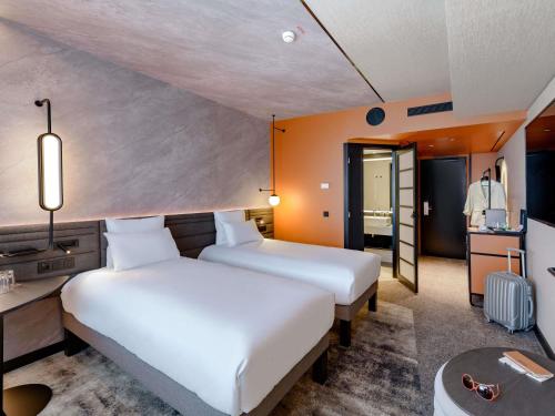 a hotel room with two beds and a kitchen at Novotel München Airport in Freising