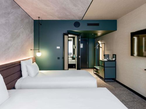 two beds in a hotel room with two beds sidx sidx sidx at Novotel München Airport in Freising