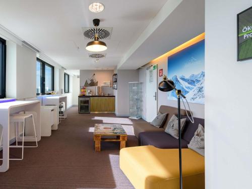 a living room with a couch and a table at Novotel München Airport in Freising