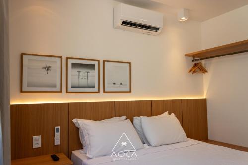 a bedroom with a bed with three pictures on the wall at Villa Naluri - Seu Refúgio a 50 metros da praia em Japaratinga in Japaratinga