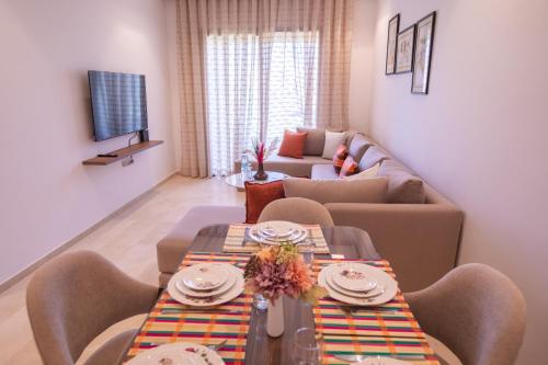 a living room with two tables and a couch at confort et détente à Marrakech-Appartement 2 Chambres avec Piscine in Marrakech