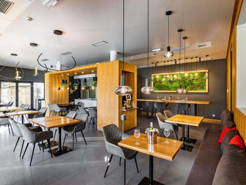 a restaurant with tables and chairs and a couch at Ibis Hotel Plzeň in Plzeň