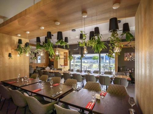 a restaurant with a long table and chairs at Ibis Hotel Plzeň in Plzeň