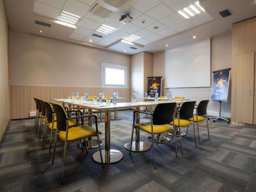 a conference room with a long table and chairs at Ibis Hotel Plzeň in Plzeň