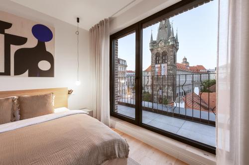 a bedroom with a large window with a clock tower at Turnkey I Henry's Tower Apartments in Prague