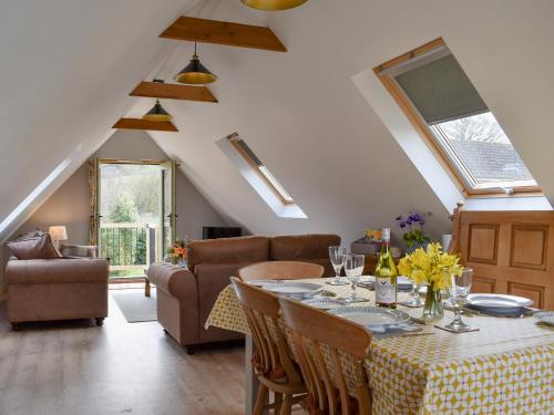a dining room with a table and a couch at The Haybarn in Woolland