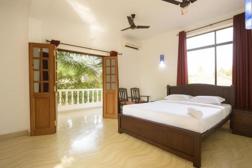 a bedroom with a bed and a sliding glass door at Sandeep Gurung Homes Stay in Calangute