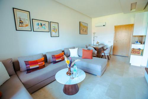 a living room with a couch and a table at confort et détente à Marrakech-Appartement 2 Chambres avec Piscine in Marrakech