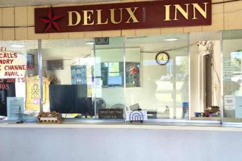 a store front with a window with a clock on it at Deluxe Inn Motel By OYO Grand Prairie Interstate 30 in Grand Prairie