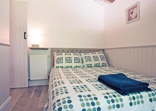 a bedroom with a bed with a blue blanket at Great Wood Lodges in Flaxton
