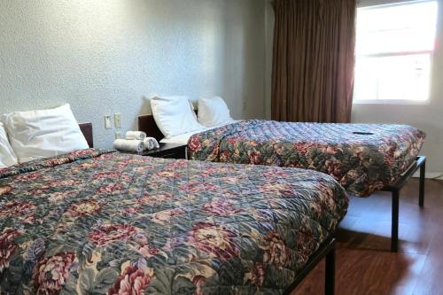 a hotel room with two beds and a window at Deluxe Inn Motel By OYO Grand Prairie Interstate 30 in Grand Prairie