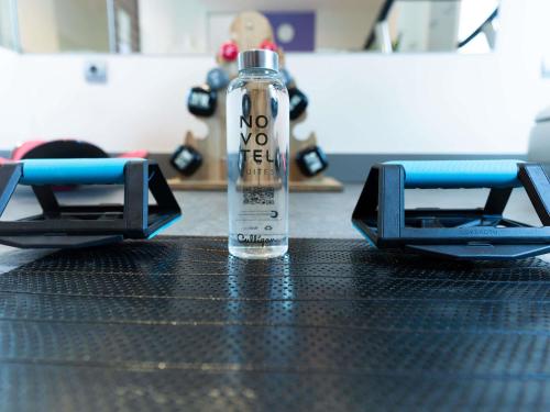 a bottle of water sitting on top of a table at Novotel Suites Malaga Centro in Málaga