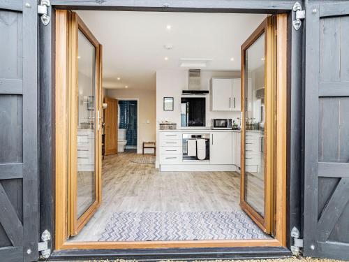 an open door into a kitchen with white cabinets at Wisteria Lodge - Ukc5804 in Shelfanger