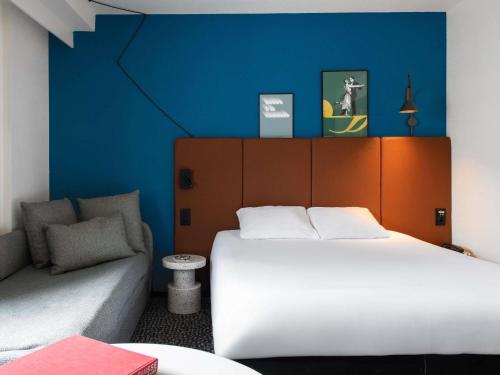 a hotel room with a bed and a couch at ibis Lausanne Centre in Lausanne