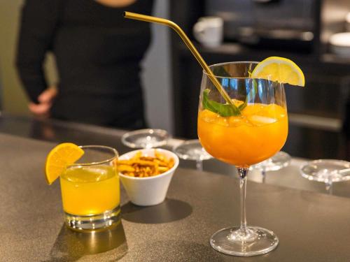 two glasses of orange juice and a bowl of food at ibis Lausanne Centre in Lausanne