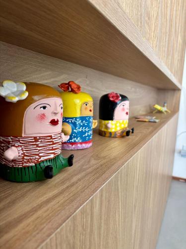 a wooden shelf with dolls on top of it at Villa Naluri - Studio A001 no paraíso Japaratinga! in Japaratinga