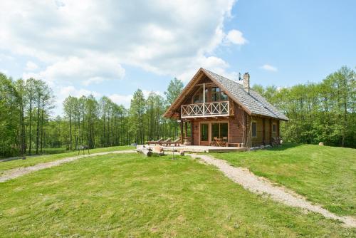 a house on top of a grassy hill at Dabintos slėnis in Sumiliszki