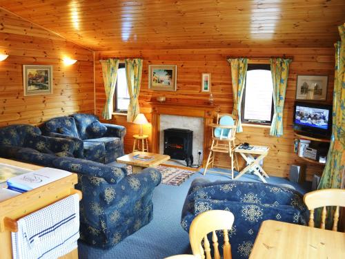 sala de estar con muebles azules y chimenea en Glenmore Lodge, en Keswick