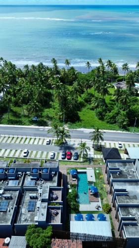 an aerial view of a resort with the beach at Villa Naluri - Studio A001 no paraíso Japaratinga! in Japaratinga