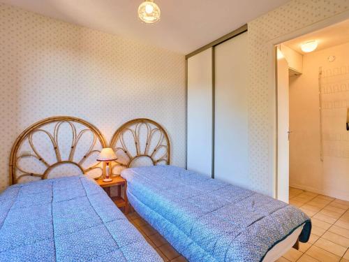 a bedroom with two beds and a lamp on a table at T2 lumineux pour 2, animaux admis, parking, WiFi - FR-1-841-47 in Barbotan-les-Thermes