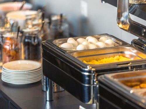 a buffet with eggs in a tray of food at Ibis Lugano Paradiso in Lugano