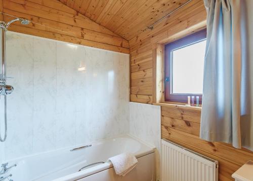 a bathroom with a white tub and a window at Trewythen Lodges in Caersws