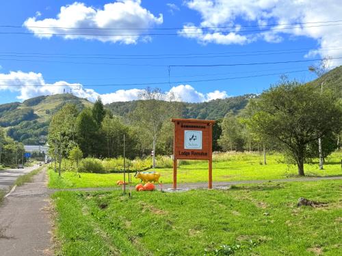 a sign with a clock in the middle of a field at Lodge Romulus in Rusutsu