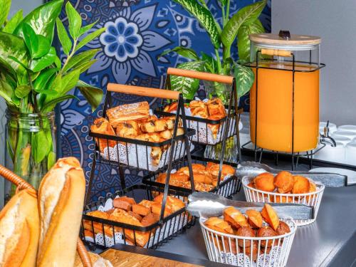 a table topped with baskets of bread and pastries at Ibis Styles Dakar in Dakar