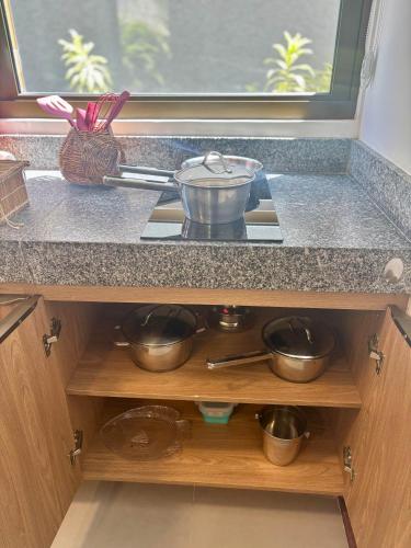 a kitchen counter with pots and pans on a stove at Villa Naluri - Studio A001 no paraíso Japaratinga! in Japaratinga