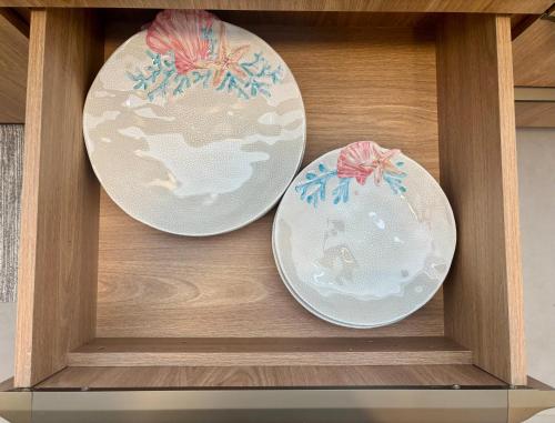 three plates in a wooden shelf in a drawer at Villa Naluri - Studio A001 no paraíso Japaratinga! in Japaratinga