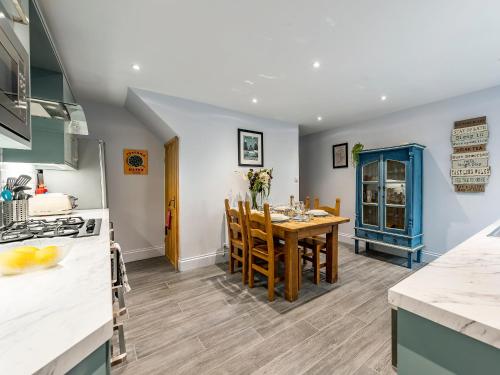 Una cocina y un comedor con mesa y sillas. en Carrie's Gate, en Coniston